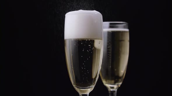 Waiter Pours the Champagne Into the Glass. Black Background. Close Up