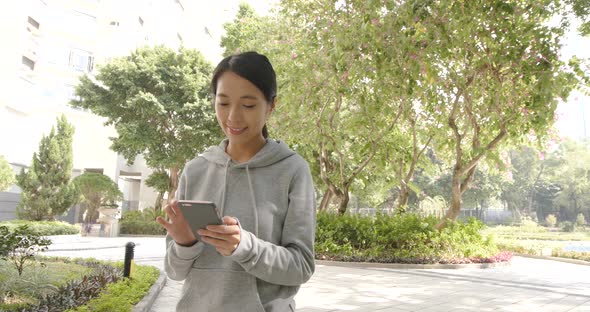 Woman use of cellphone and walking in the park