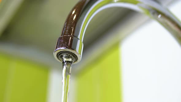 Water Running From the Tap Into a Sink