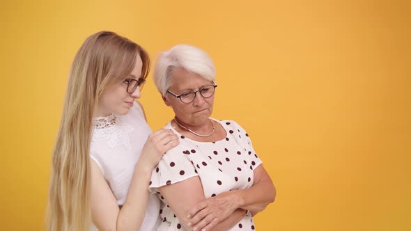 Young Woman Calming Down Senior Lady After Bad News. Family Love and Care Concept