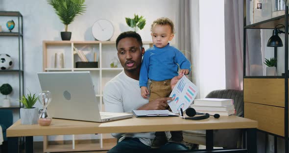 Father Which Stayed at Home with His Little Kid and Talking with Colleagues Via Video Meeting