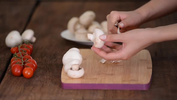  Woman is peeling off mushroom on kitchen.