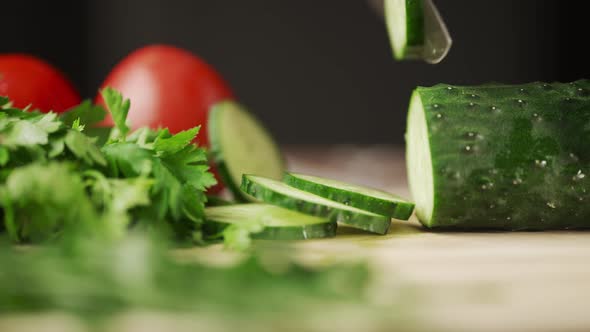 A Man Hands are Cutting a Ripe Green Cucumber