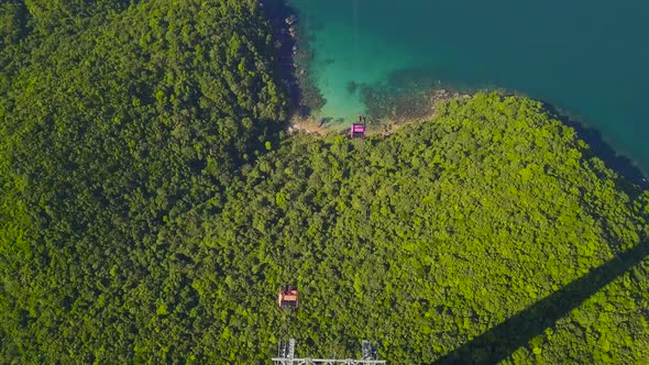 Drone View. Cable Cars Moving on Aerial Tramway Crossing the Ocean and Mountains