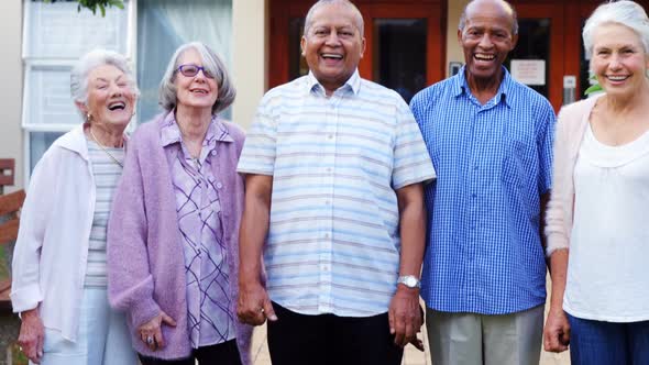 Happy senior friends standing together in lawn 4k