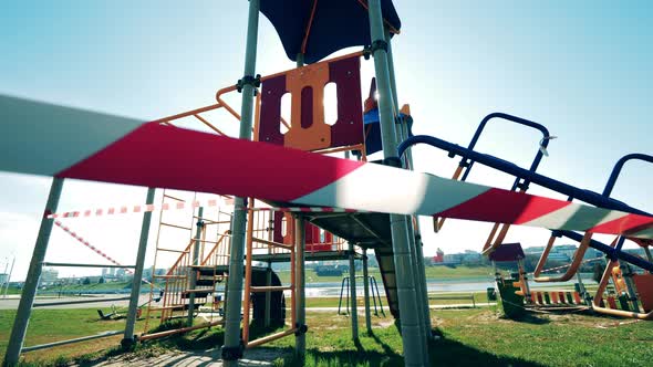 Sunlit Playground with a Barricade Tape Wrapped Around It