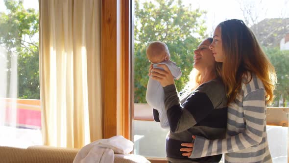 Lesbian couple holding their baby boy 4k