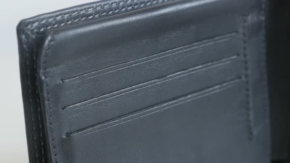 Tilting on black leather wallet on white background 3840X2160 UltraHD footage - Details of bi-fold m
