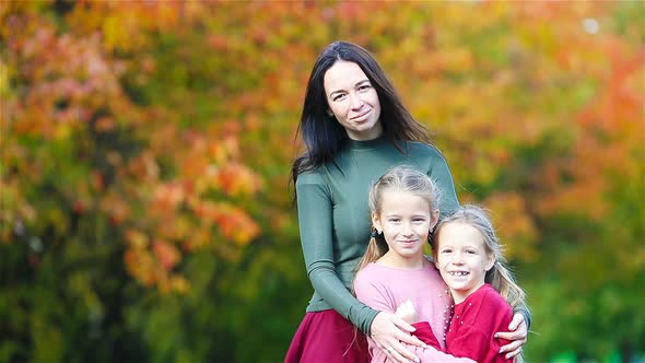 Family of Mom and Kids in Fall. Young Mother and Little Girls Enjoy Warm Autumn