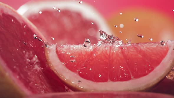 Slow Motion Shot of Grapefruit Water Splashing Through Grapefruit Slices