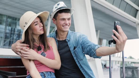 Couple Traveling, Making Photo On Phone Near Airport