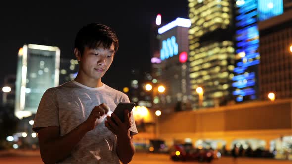 Man use of mobile phone in city at night 