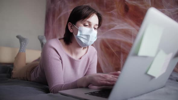 Woman freelancer on the bed, distance learning for students. Coronavirus. Quarantine. Freelancer.