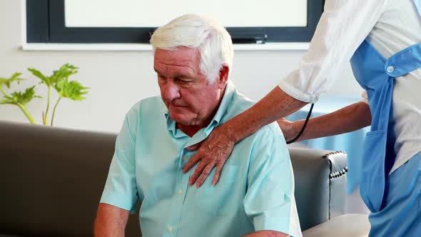 nurse listening to chest of patient with stethoscope