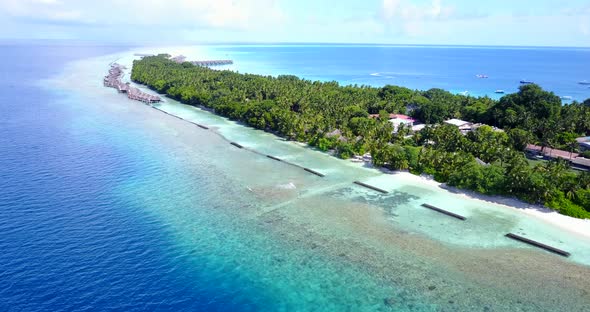 Tropical above travel shot of a white paradise beach and blue sea background in 4K