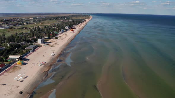 Beautiful flight in summer over the beach. People are resting near the sea.