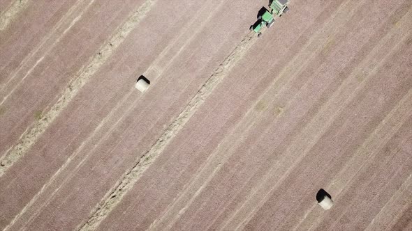 Aerial Footage Overhead Approaching Hay Bailer In Field