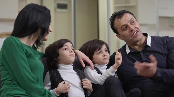 Medium Shot of Carefree Relaxed Happy Multinational Family Discussing Movie Watching TV on Weekend