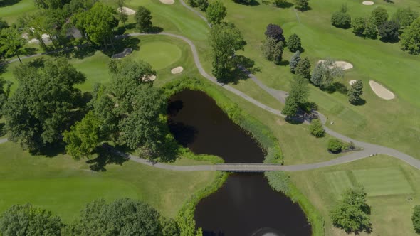 Tilt Up from a Golf Course to Aerial View of a Village in Long Island