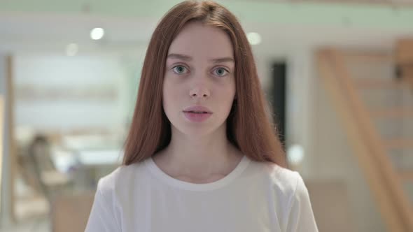 Portrait of Redhead Young Woman Saying No By Shaking Head