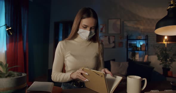 Young Student Wearing Medical Protective Mask Using Laptop with Video Conference Call