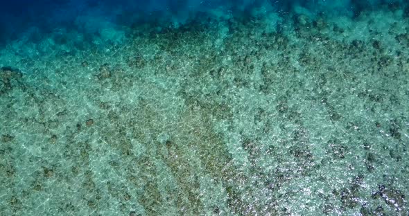 Tropical birds eye clean view of a white paradise beach and aqua blue ocean background