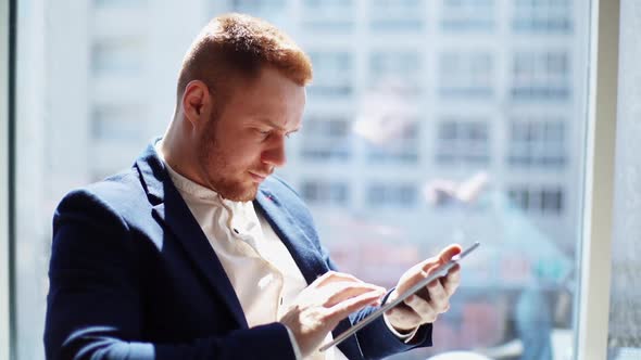 Confident Young Businessman Wearing Fashion Suit Is Using Digital Tablet