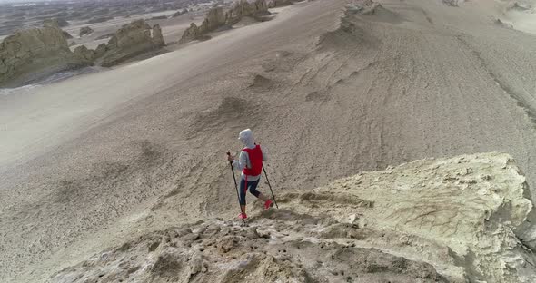 Aerial footage of woman trail runner cross country running  on sand desert dunes