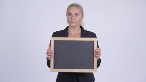 Young Happy Blonde Businesswoman Thinking While Holding Blackboard
