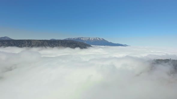 Drone filmed a video above the clouds enveloping all surfaces of the earth in California, USA