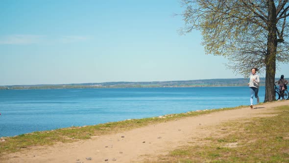 Young Healthy Woman Jogging at the Beach at Sunny Day