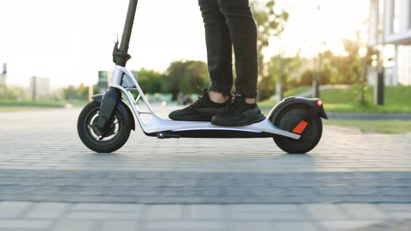 Legs Man in Black Sneakers Ride on Electric Mobile Scooter