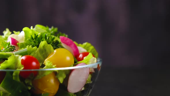 Fresh vegetable salad from cucumber, tomato and lettuce on black background