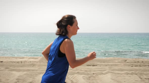 Female jogging on beach to lose weight.