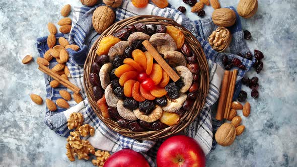 Composition of Dried Fruits and Nuts in Small Wicker Bowl Placed on Stone Table