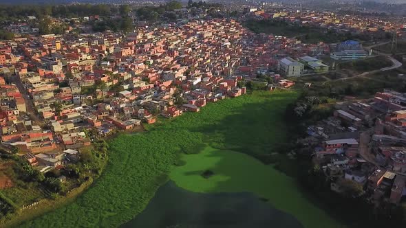 Beautiful cinematic aerial footage over the lake and favelas in Sao Paulo, Brazil