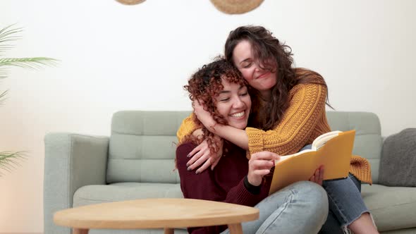 LGBT Hispanic Lesbian Couple Reading a Book Indoor at Home  Gay Love Relationships Concept