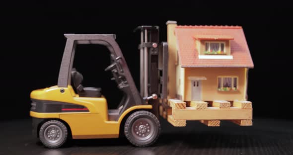Forklift Truck Holds a House on a Pallet
