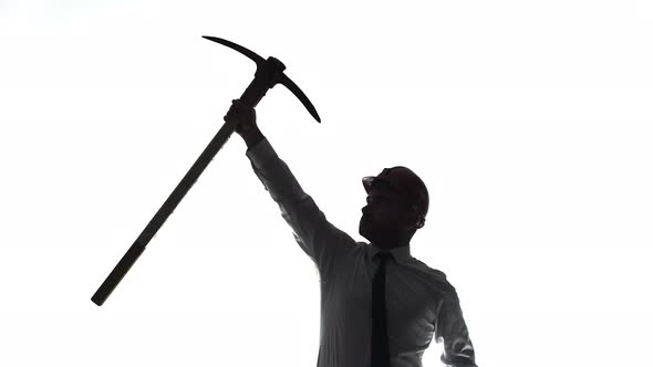 Caucasian Man in Office Clothes Stand on a White Background Hold a Pickaxe Up at Arm Length Then