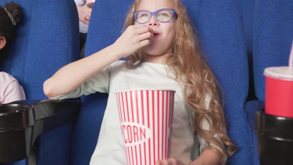 Happy Multiracial Kids Eating Popcorn and Watching Movie