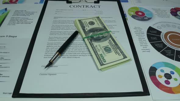 Business Contract And Dollars On The Desk In The Office Of A Modern Company