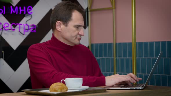 Businessman Quickly Typing Contract on Laptop Keyboard Working Remotely in Cafe