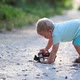 Baby plays a toy car on the road - VideoHive Item for Sale