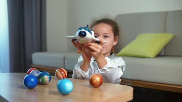 Child Plays at Home in an Astronaut Funny Portrait of a Little Girl 89 Years Old in a Toy Space Suit