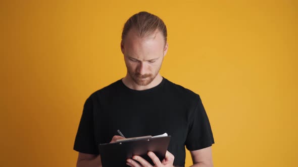 Concentrated man writing on the tablet