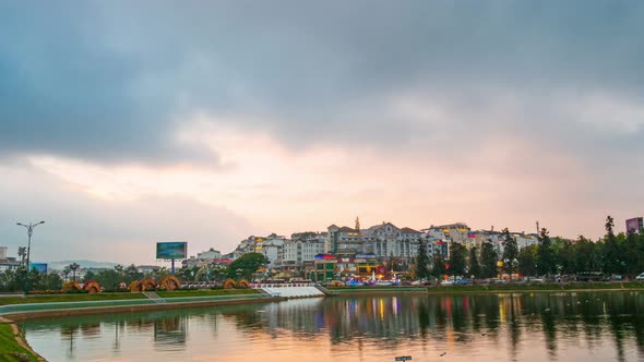 Day to night time lapse Dalat city centre Vietnam cityscape reflection on lake at sunset