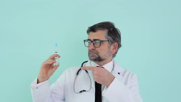 Doctor Holds a Syringe and Vaccine Bottle at the Hospital on Blue Background