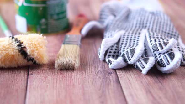 A Paint Brush  Gloves and Paint on Table