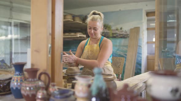 Happy Blonde Woman Working with Clay in Studio