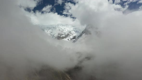 Epic aerial drone shot through the clouds of a snowy peak in the Annapurna mountains, Nepal